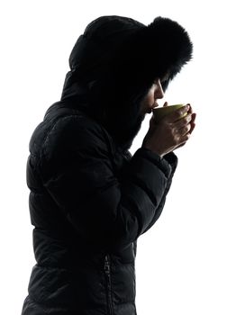 one woman in winter coat drinking hot drink silhouette on white background
