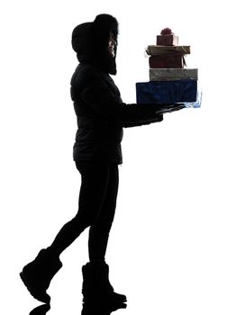 one woman in winter coat walking carrying christmas gifts silhouette on white background