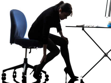 one business woman massaging her leg silhouette studio isolated on white background
