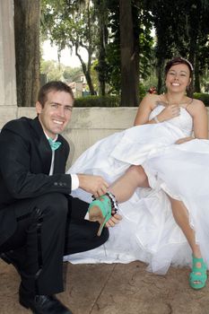 A handsome groom removes the garter from his bride's leg.