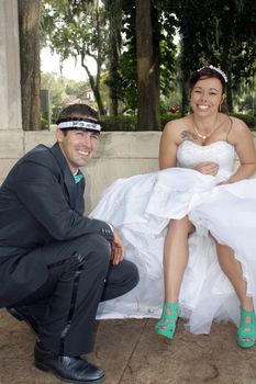 A handsome groom playfully wears his bride's garter on his head.