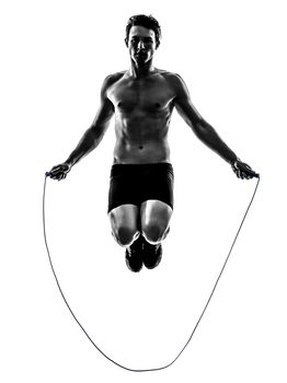 one caucasian man exercising jumping rope in silhouette studio on white background
