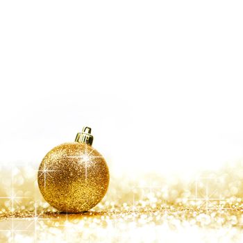 Golden christmas ball on glitter background with white copy space