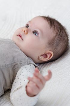 Happy cute baby girl lying on back