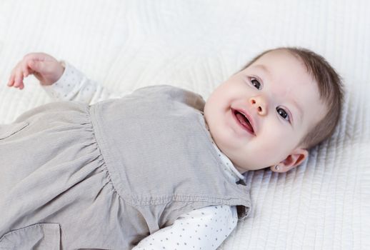 Happy cute baby girl lying on back