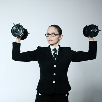 studio shot portrait of one caucasian young bsuiness woman holding weights