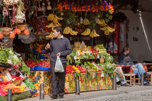 Istanbul, TURKEY ��� APRIL 28: Man leaves fruit stand with his purchase on April 28 2012 in Istanbul, Turkey.  Each year patriotic Turks honor those fallen at the battle of Galipoli during World War I.
