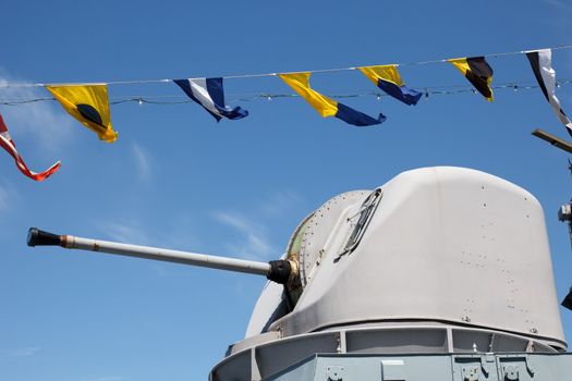 gun on warship against blue sky