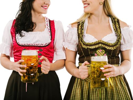 Photo of two woman wearing traditional dirndl and drinking beer.