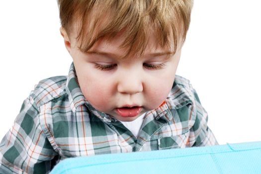 Cute little blond toddler boy looking into a blue box for discovery, growth or child development concept