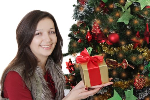 Smiling girl with gift and red ribbon under Christmas tree