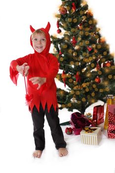 Naughty boy in devil costume near Christmas tree over white