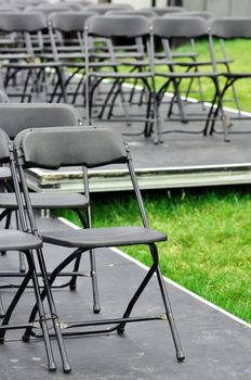 Rows of empty seats ready for outdoor wedding or concert.