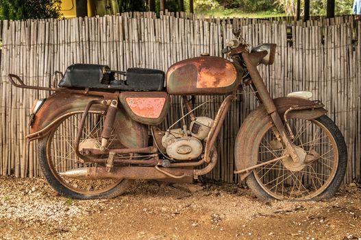 the old, rusty motorcycle on a street