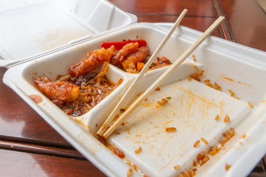 Wide angle view of left over chinese food and chopsticks