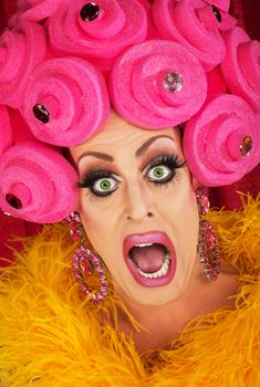 Screaming drag queen with pink foam wig in theater