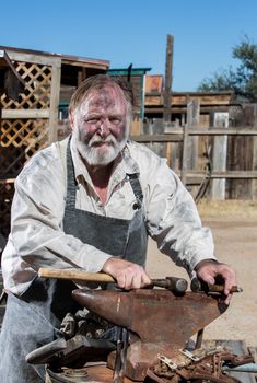 Old West Blacksmith Rests Hammer on Anvil
