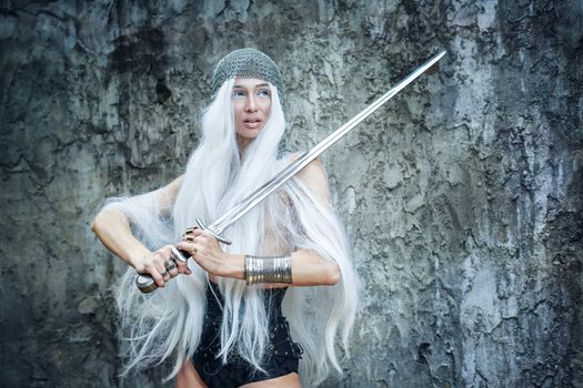 Attractive gray-haired maiden warrior in armor with sword in hand