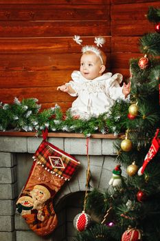 Cute little girl dressed as snowflakes near the Christmas tree and decorations