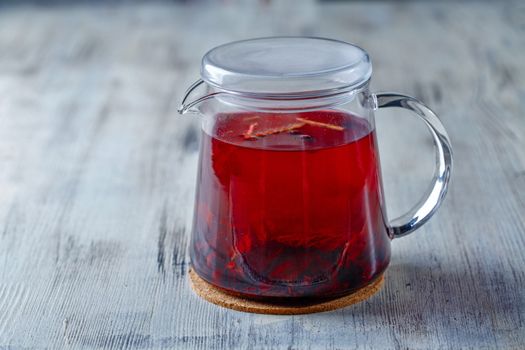 Glass tea kettle on the wooden table closeup shot