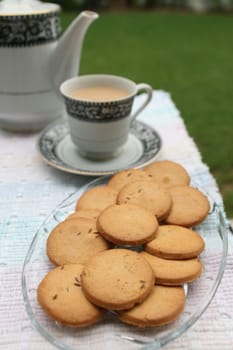 Tray full of biscuits served with tea pot and a cup