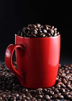 Red cup full of roasted brown coffee beans