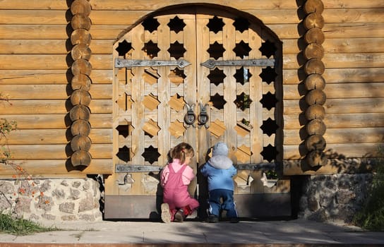 Children looking through the wooden gates