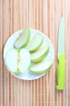 Apple pieces on the plate at the textured background