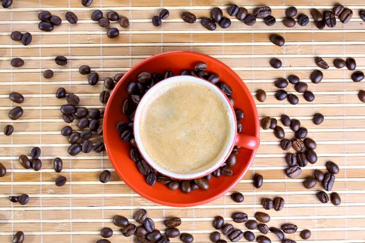 Cup of coffee with roasted beans at wooden background