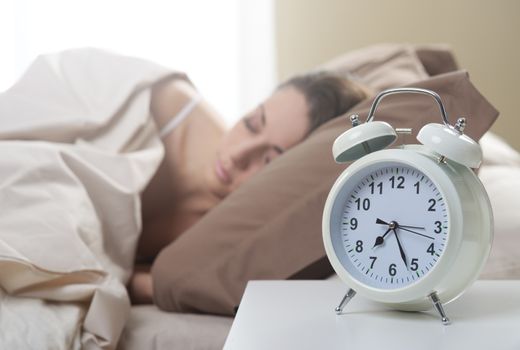 Young beautiful woman sleeping comfortably on bed