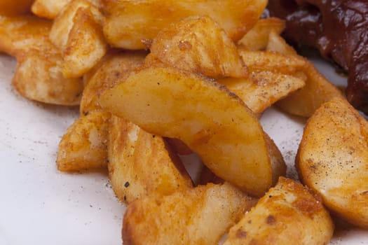 Golden Fried Crisp Potato Wedges on a white plate.