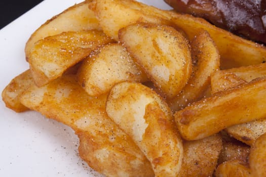 Golden Fried Crisp Potato Wedges on a white plate.