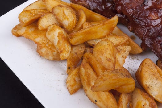 Golden Fried Crisp Potato Wedges on a white plate.