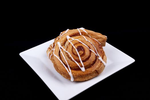 cinnamon danish  on white plate.