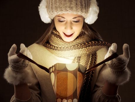 Young woman opening a shopping bag full of Christmas magic