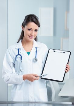 Confident woman doctor pointing at the clipboard