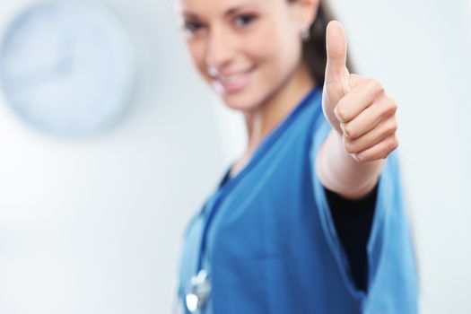 Young female doctor gesturing with thumbs up