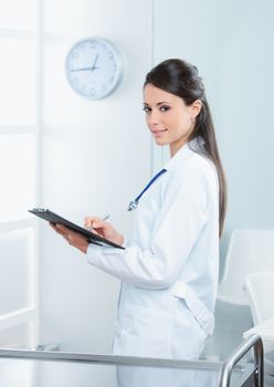 Portrait of a smiling female doctor working on her report 
