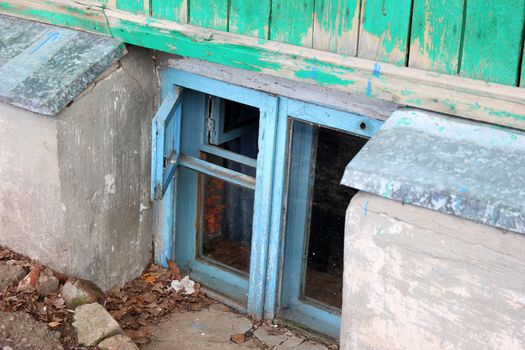 small window in the basement of a wooden house