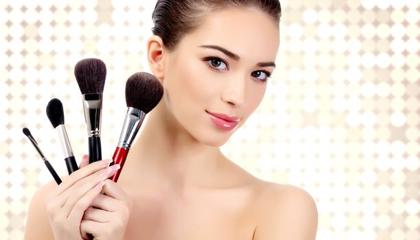 Pretty woman with cosmetic brushes against an abstract background with circles and copyspace