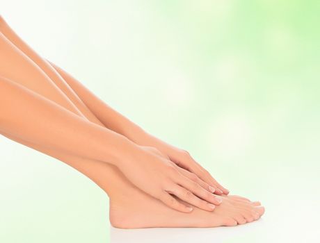 woman feet and hands on floor, green blurred background