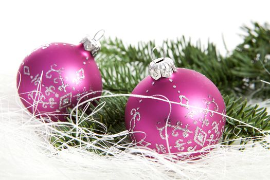 Two pink Christmas balls and pine tree over white background