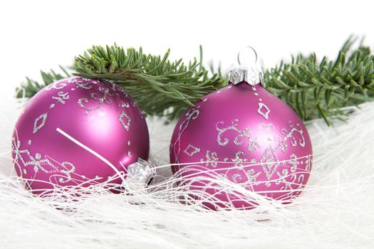 Two pink Christmas balls and pine tree over white background