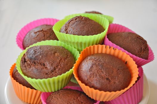 Muffins in colourful plastic cups