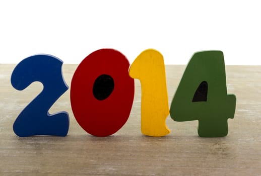 text new year 2014 in wooden letters blue red green yellow on wooden plate