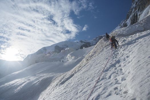 Group of mens on the ice in mountains.