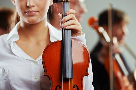 Close up portrait of a female violinist, musicians on background