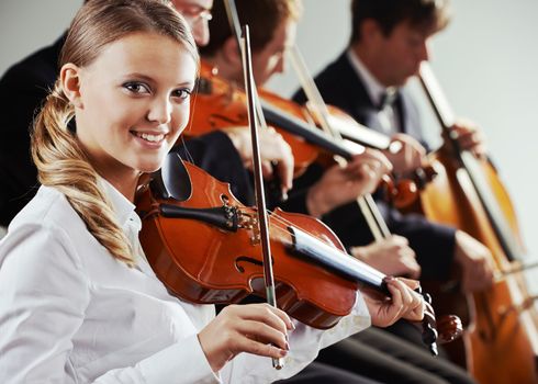  Musicians in concert, beautiful female violinist on foreground