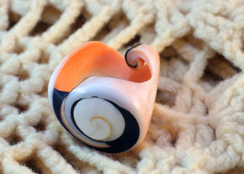 Original handmade ring of sea shell on the knitted background