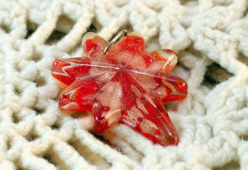 Glass star red pendant handmade on the knitted background